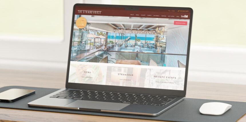 The Strand House website on a laptop